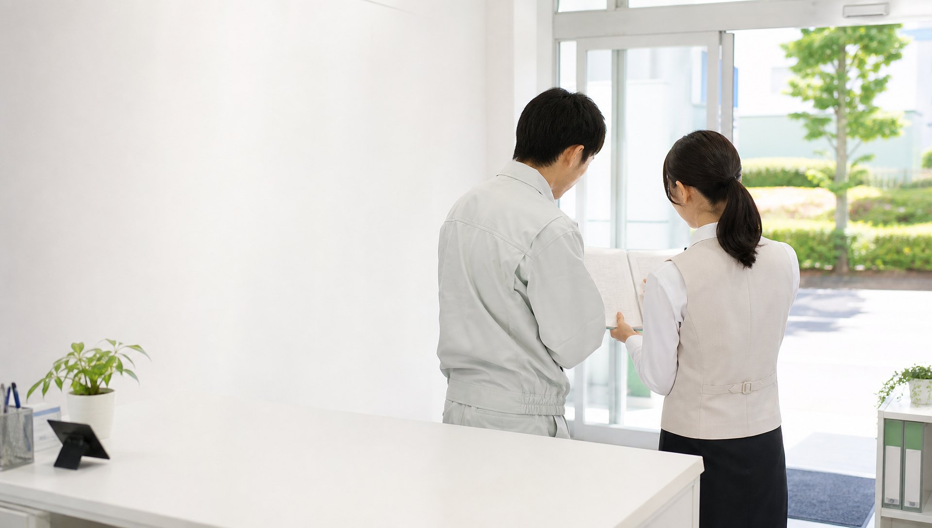 帰社した作業員と事務担当者が当日の作業を確認する場面のイメージ